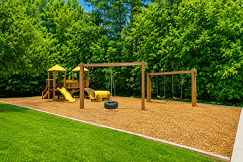 Outdoor playground with wooden swings and slide